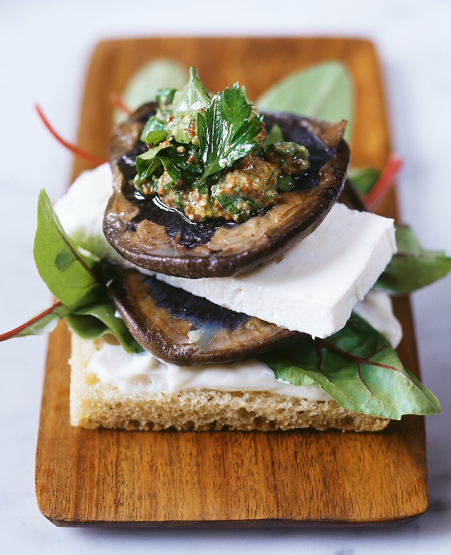 Pilz-Feta-Sandwich mit Senfdressing auf Holzbrett