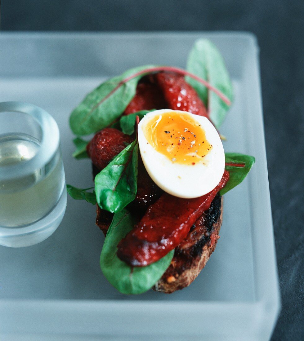 Toasted garlic bread topped with chorizo, lettuce and egg