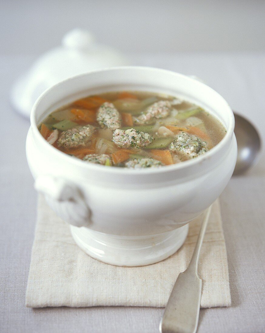 Vegetable soup with bacon dumplings in a soup tureen