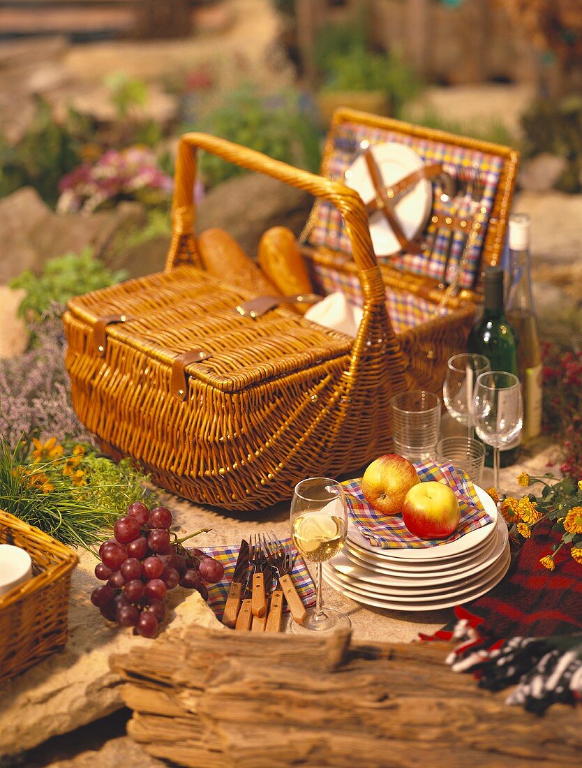 Still life with picnic basket, crockery, glasses and wine