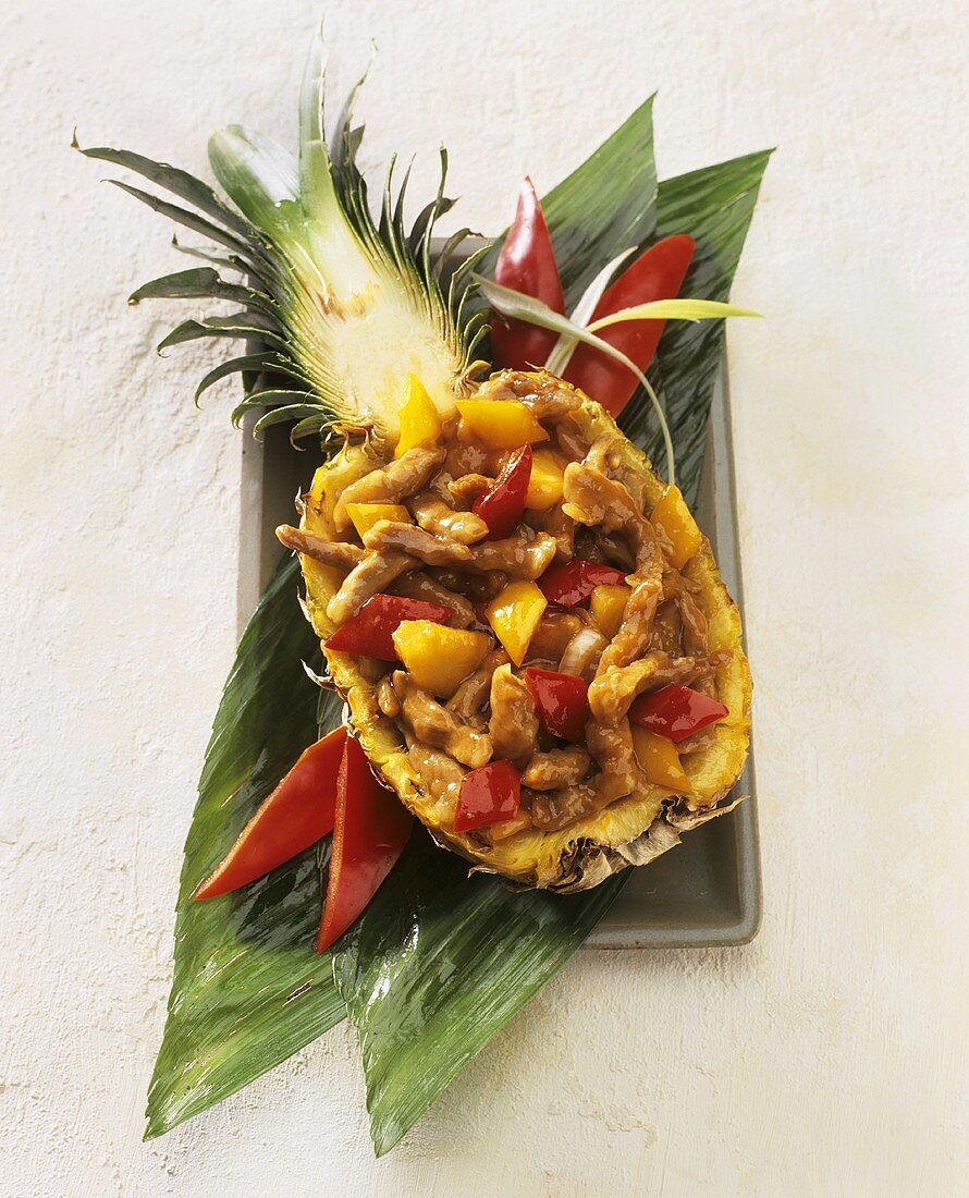 Sweet and sour pork served in hollowed-out pineapple