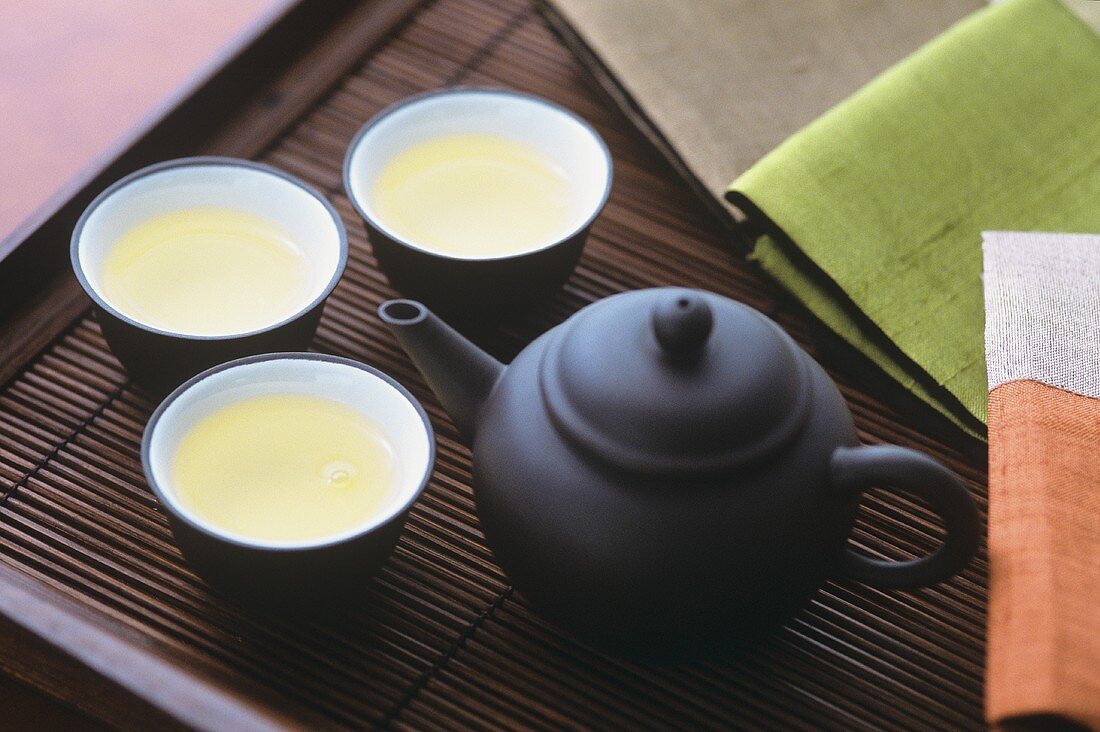 Drei Tassen grüner Tee in chinesischem Teeservice
