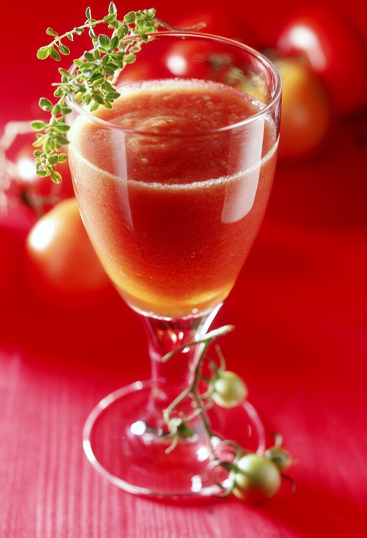Tomato juice in glass with sprig of thyme