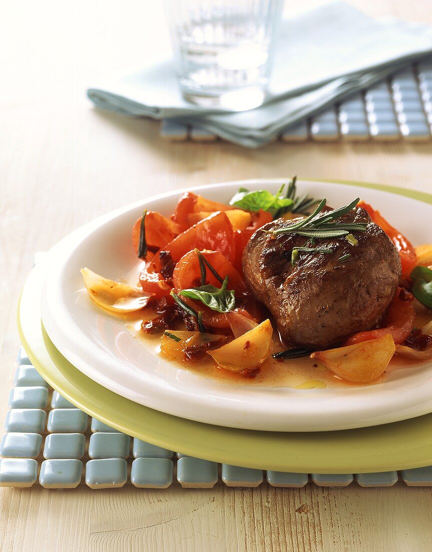Lamb steak with rosemary on tomatoes