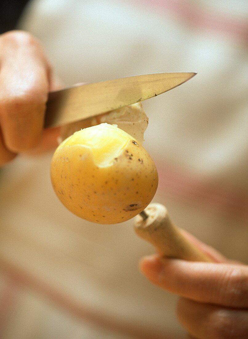 Kartoffeln mit Pellgabel und Messer pellen
