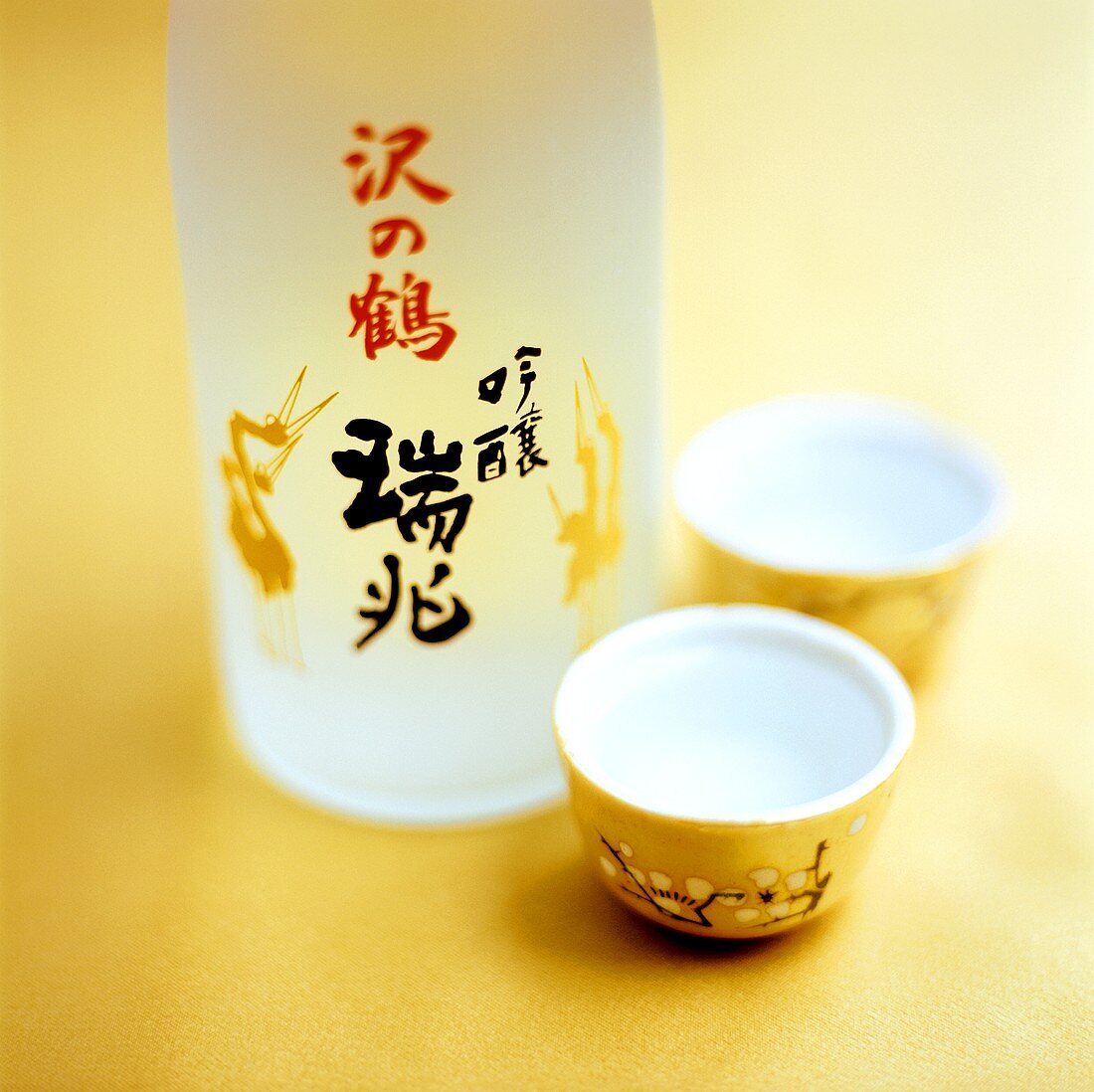 Sake in Flasche und Sakebechern