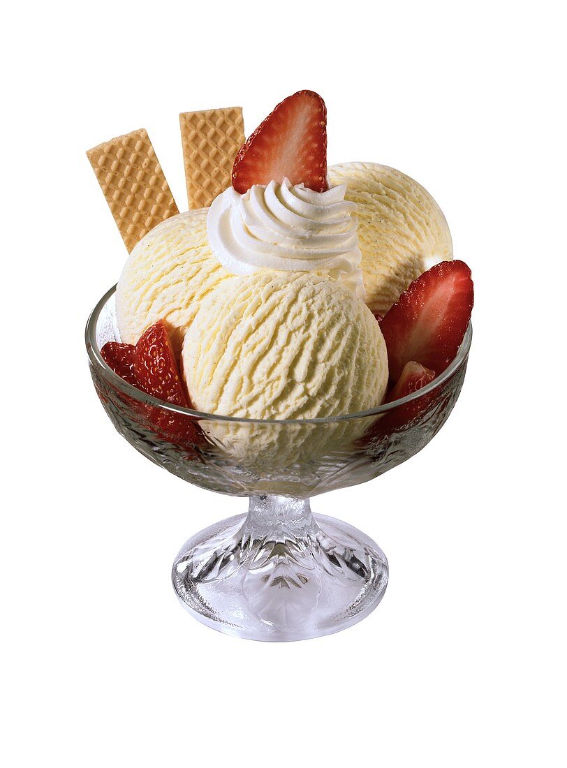 Sundae with vanilla ice cream, strawberries, cream & wafers