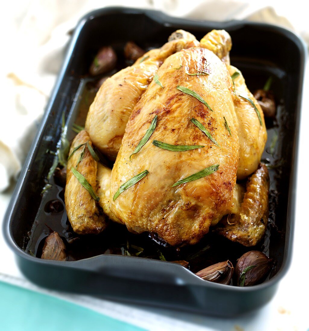 Baked chicken with tarragon and garlic in roasting dish