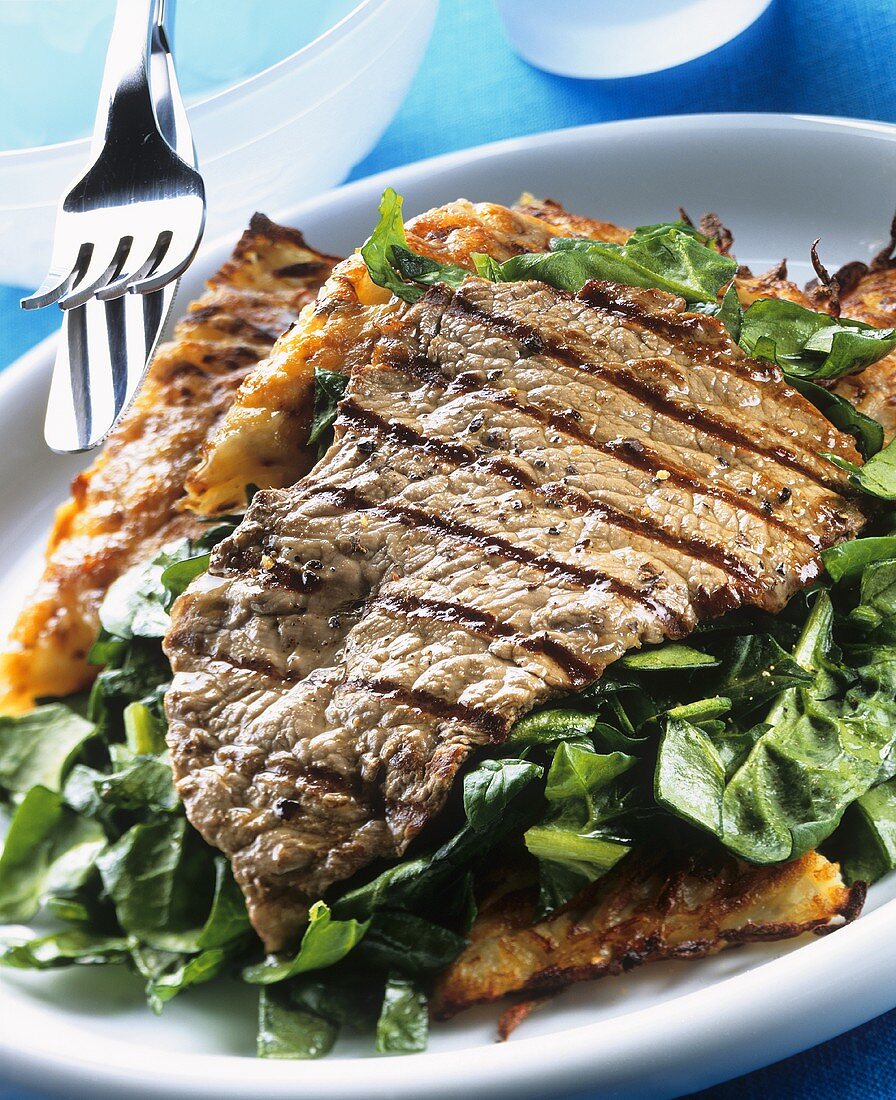 Barbecued steak with salad and potato rosti