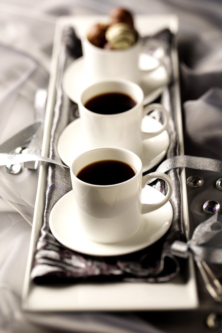 Arrangement of two cups of coffee and chocolates