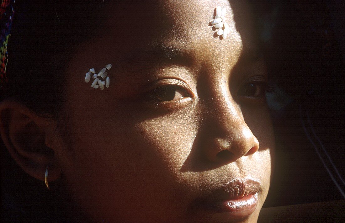 Asiatin mit Reiskörnern als Gesichtsschmuck (Tempelfest,Bali)