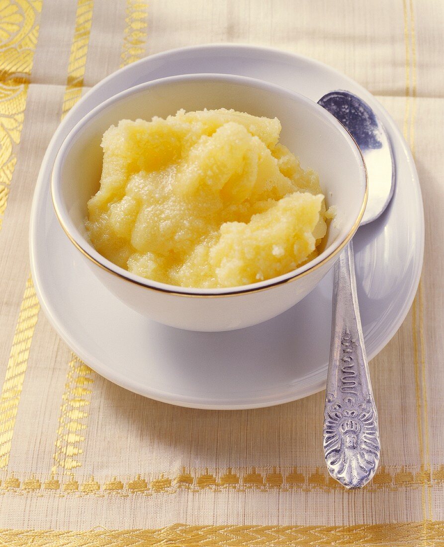 Ghee (geklärte Butter; Indien) im Schälchen mit silbernem Löffel