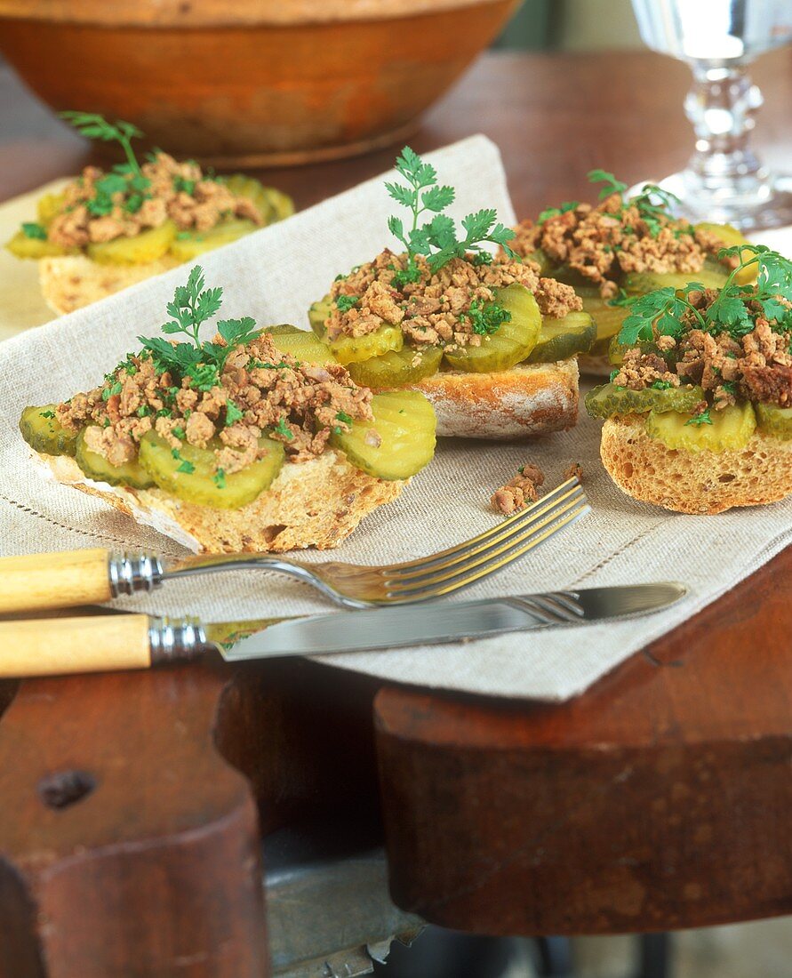 Brot mit Geflügelleber und Essiggurken belegt