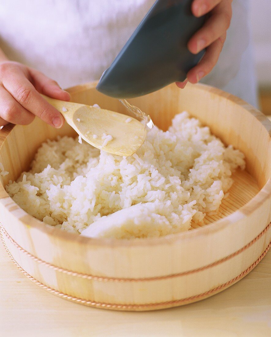 Zubereitung von Sushi-Reis im Hangiri (Zedernholzschüssel)