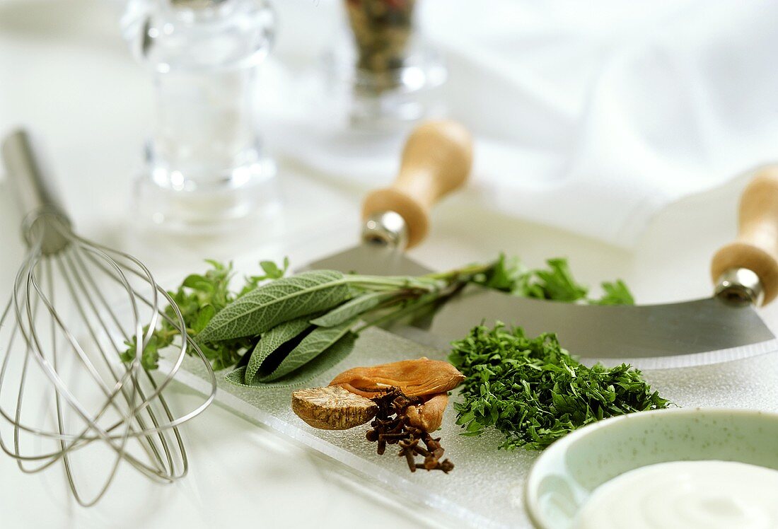 Still life with herbs, whisk and mezzaluna