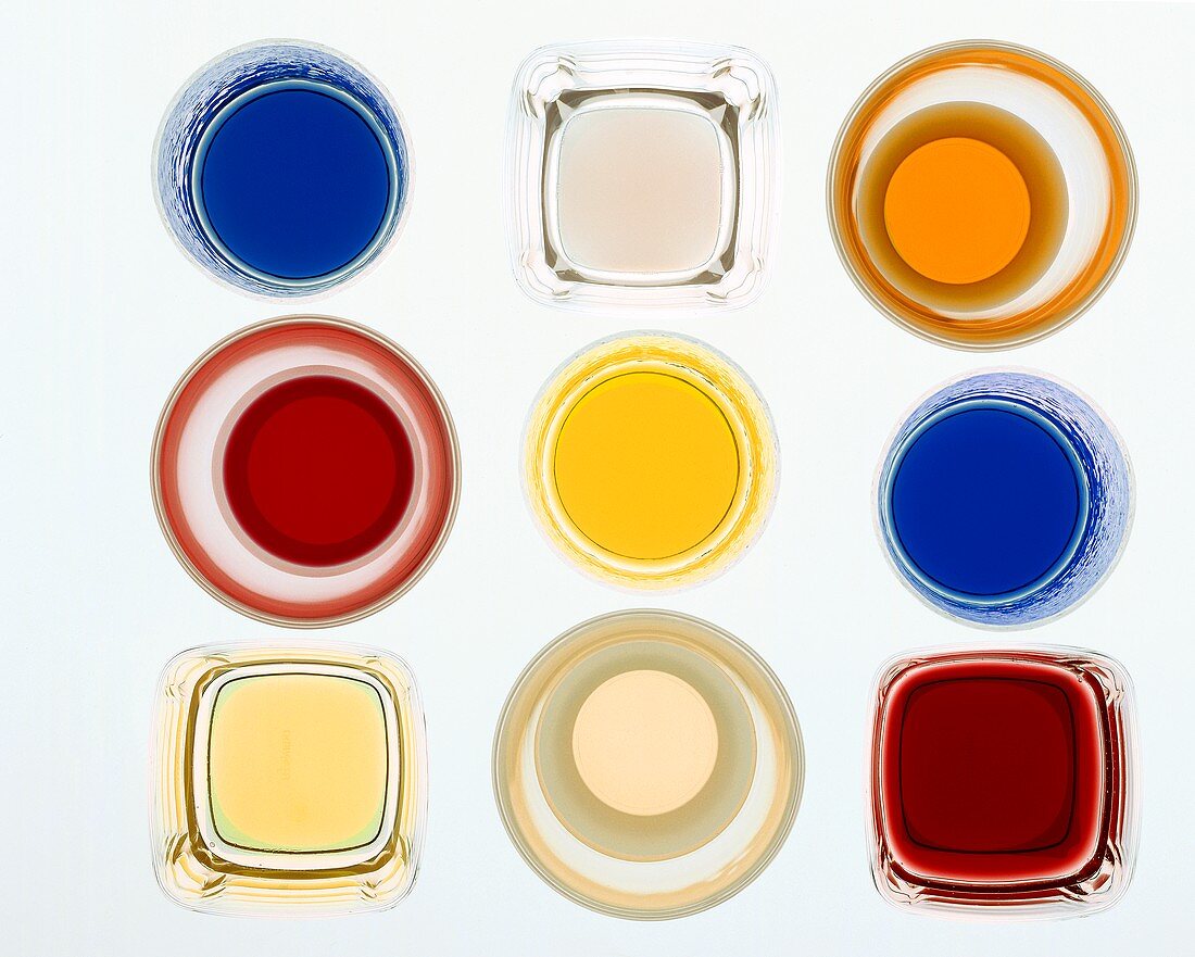 Glasses of liqueurs and sweet syrups photographed from above