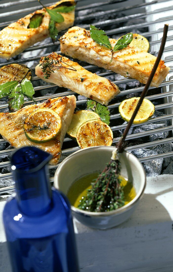 Pieces of halibut with lime and bay leaf marinade on barbecue