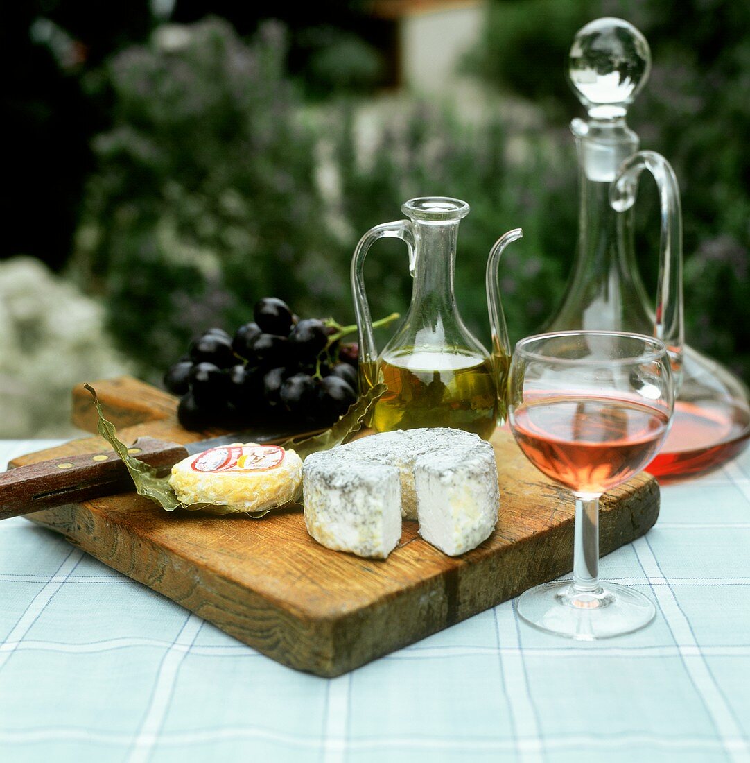 Still life with goat's cheese, rose wine and grapes