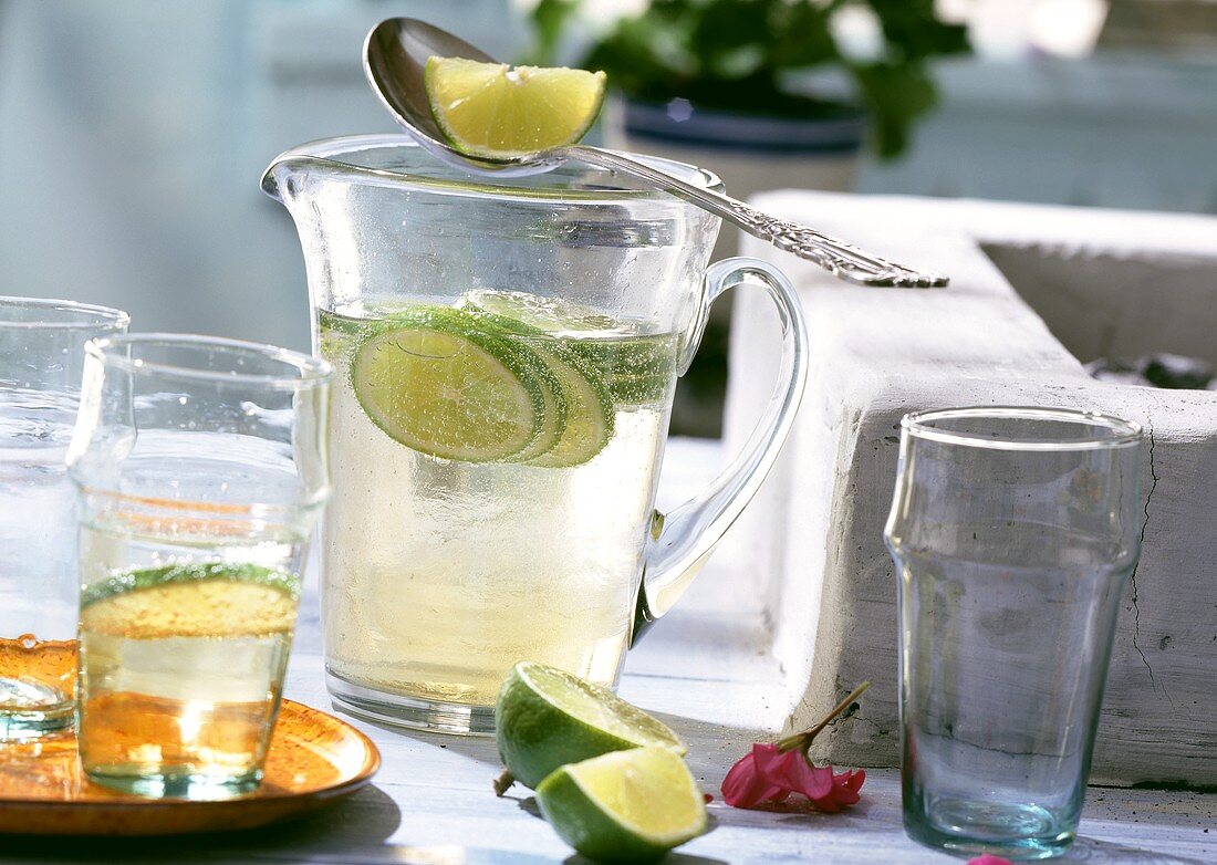 Light wine and tonic punch with lime in jug and glasses