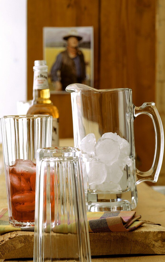 Cranberry-Whiskey-Cocktail im Glas, Krug mit Eiswürfeln