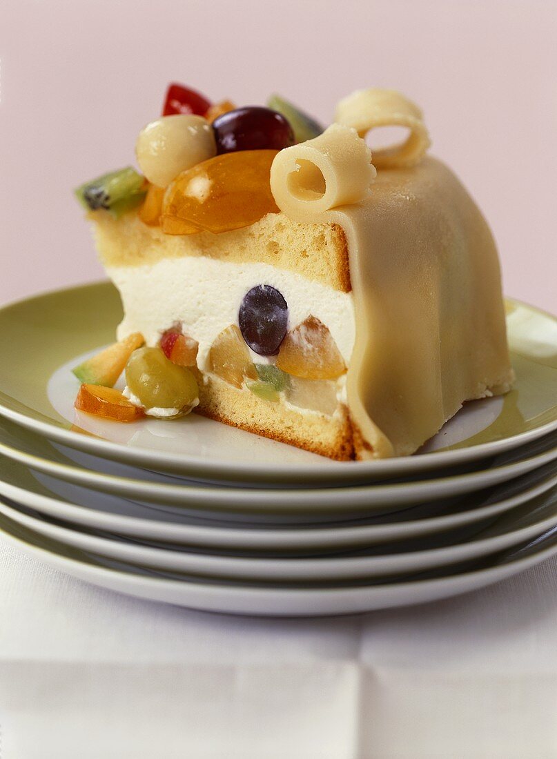 A piece of cream gateau with fruit and marzipan topping