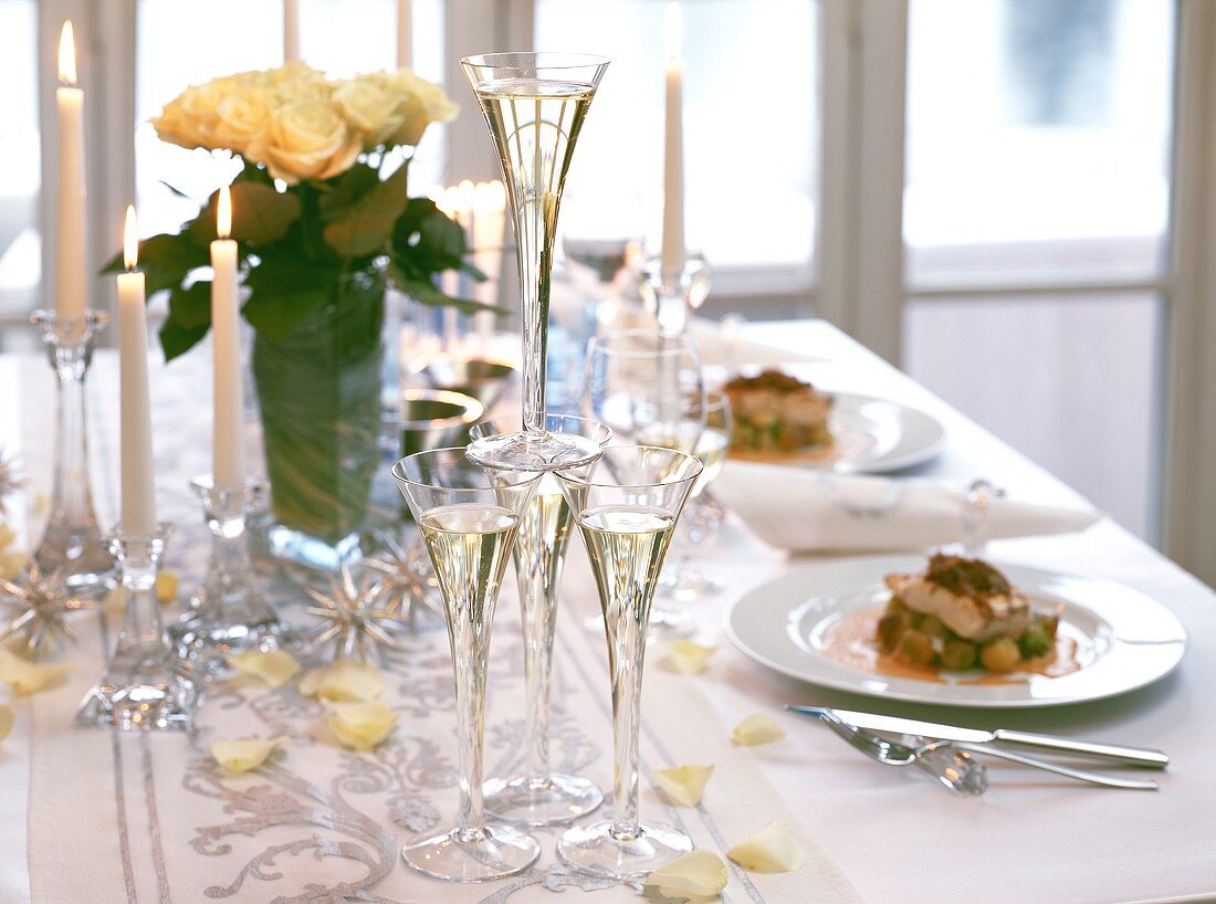 Festive table with champagne, food, roses etc