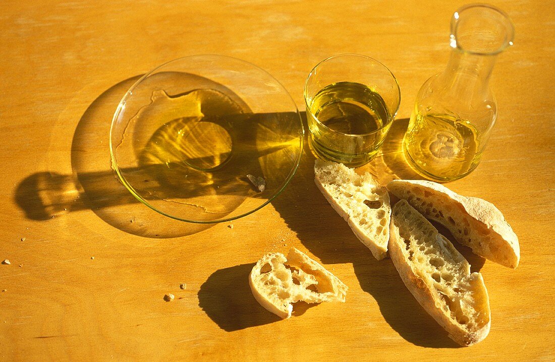 Olivenölprobe - Glas, Karaffe, Teller und Ciabatta-Brot