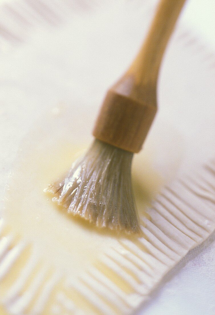 Brushing pastry with egg white with pastry brush