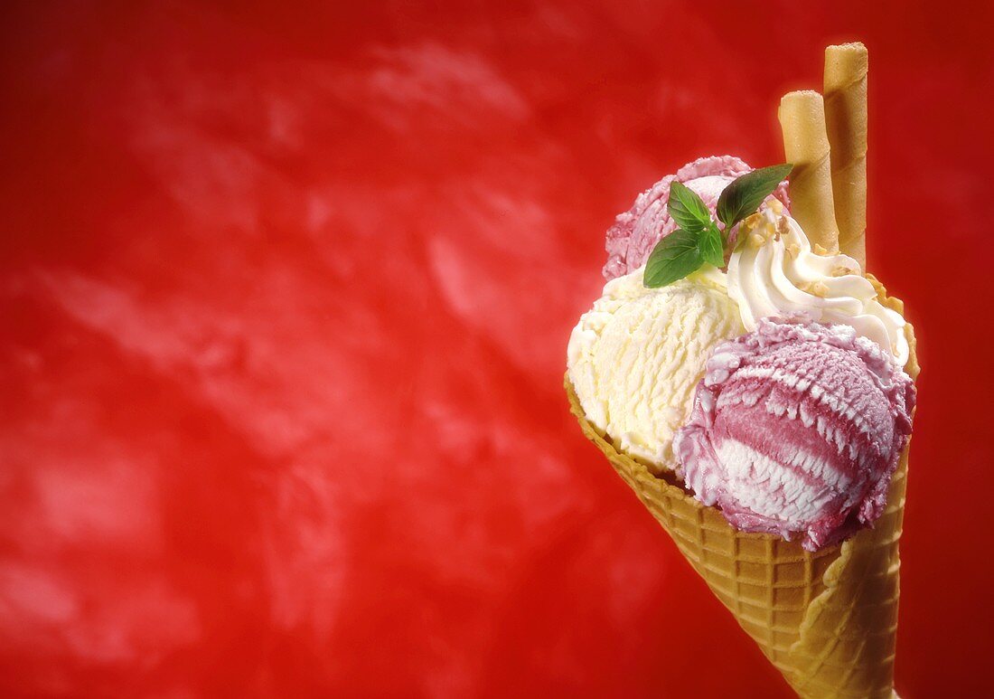 Ice cream cone with 3 scoops of ice cream, cream & wafer rolls