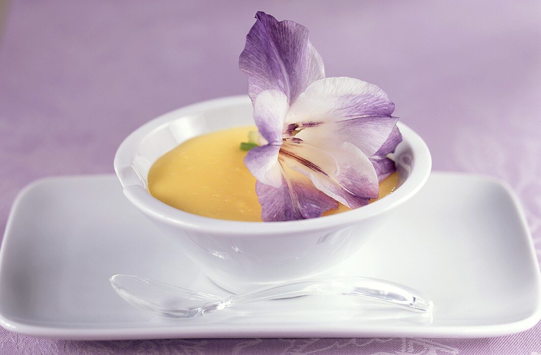 Vanilla blancmange in bowl, decorated with a flower