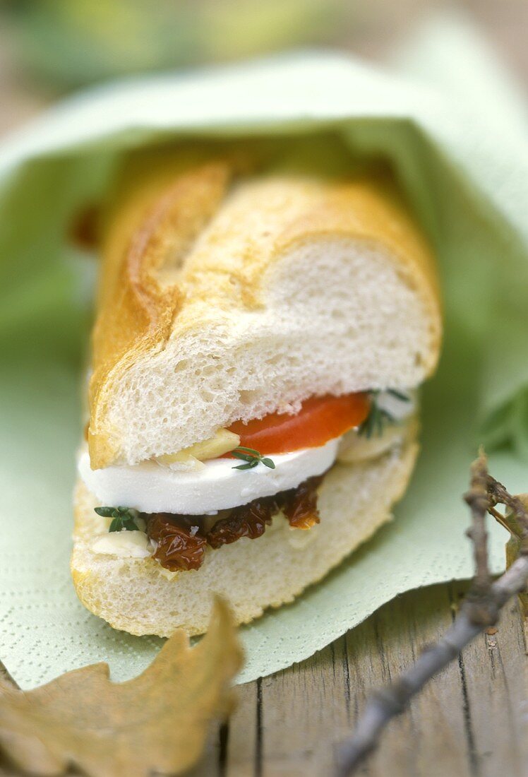 Baguette sandwich with goat cheese & tomato to eat on the move