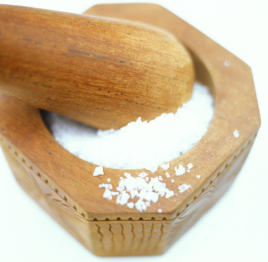 Coarse sea salt in wooden mortar