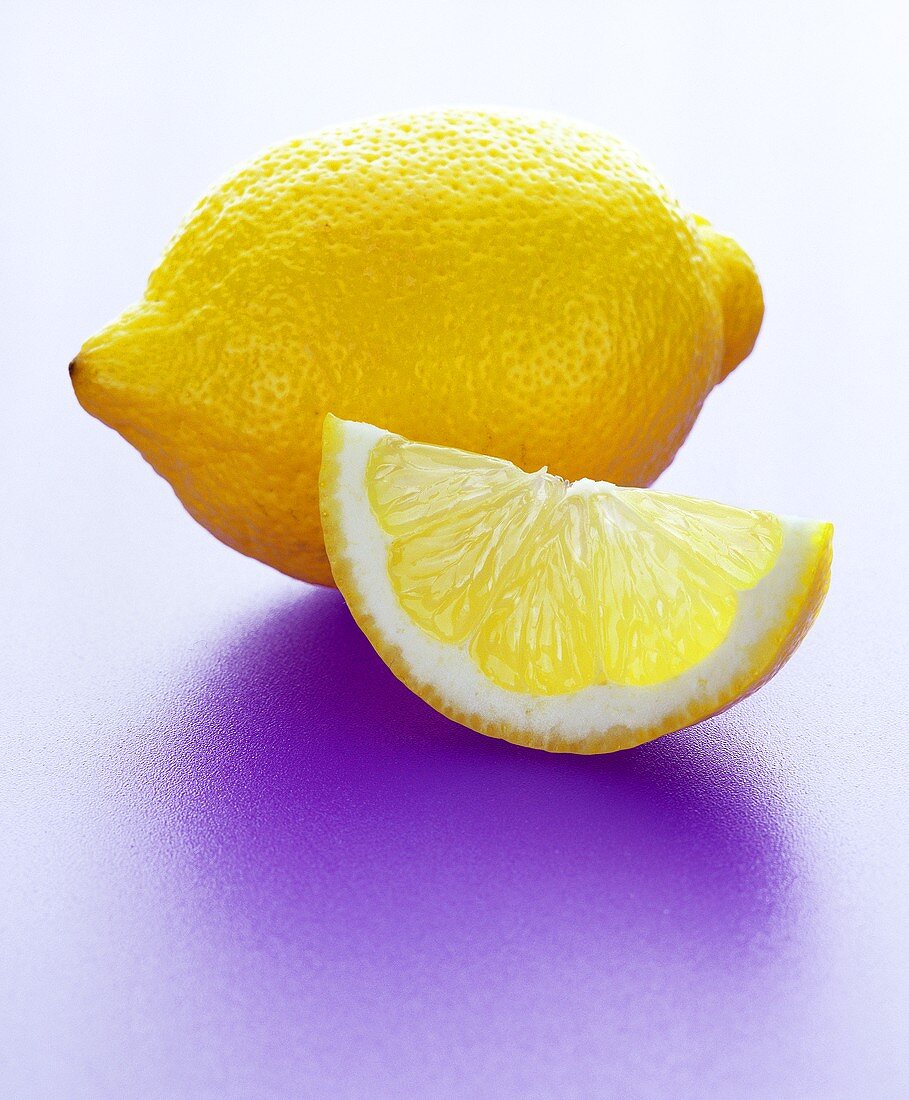 Ganze Zitrone und Zitronenspalte
