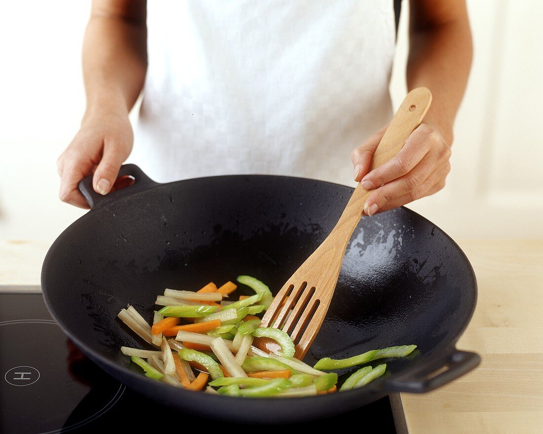Frying vegetables in wok