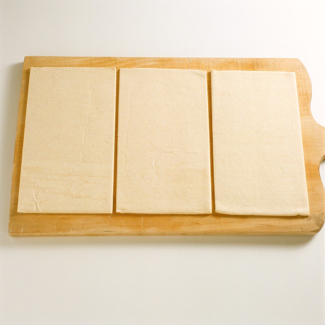 Frozen puff pastry on chopping board