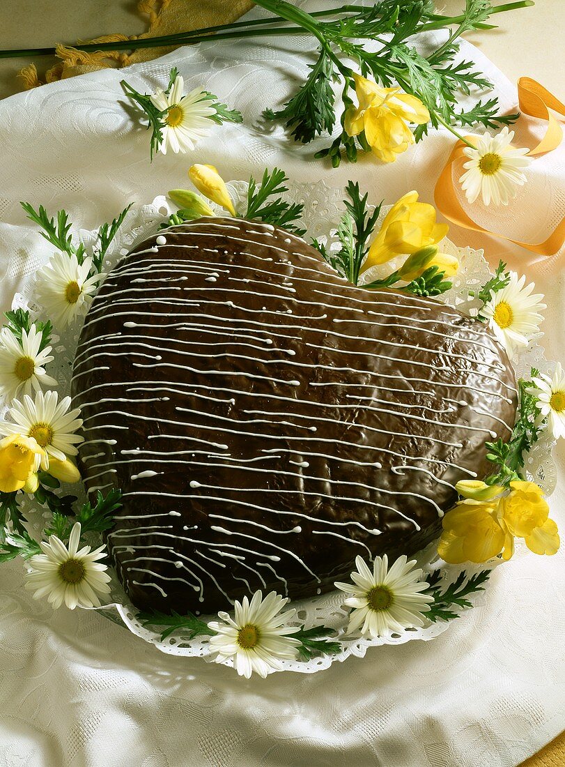 Baumkuchen-Herz mit Schokoladenglasur und Blüten