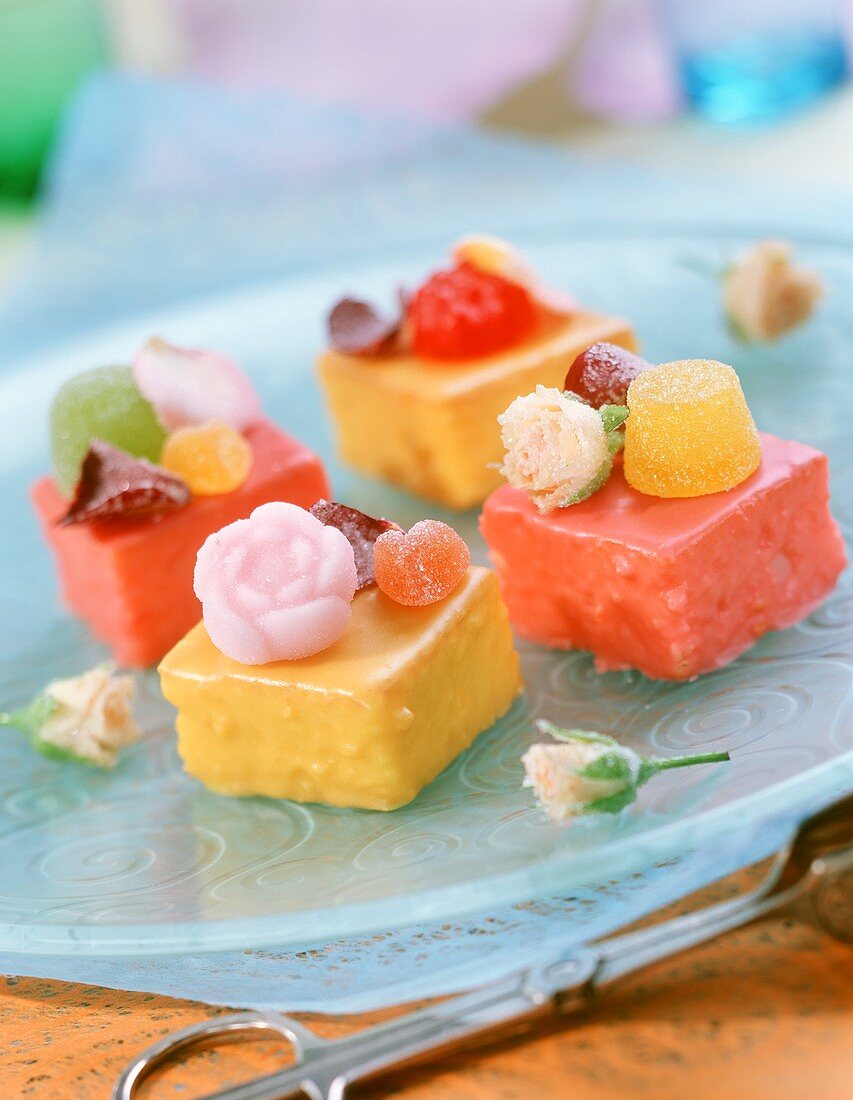 Petit fours mit Geleefrüchten und kandierten Rosen