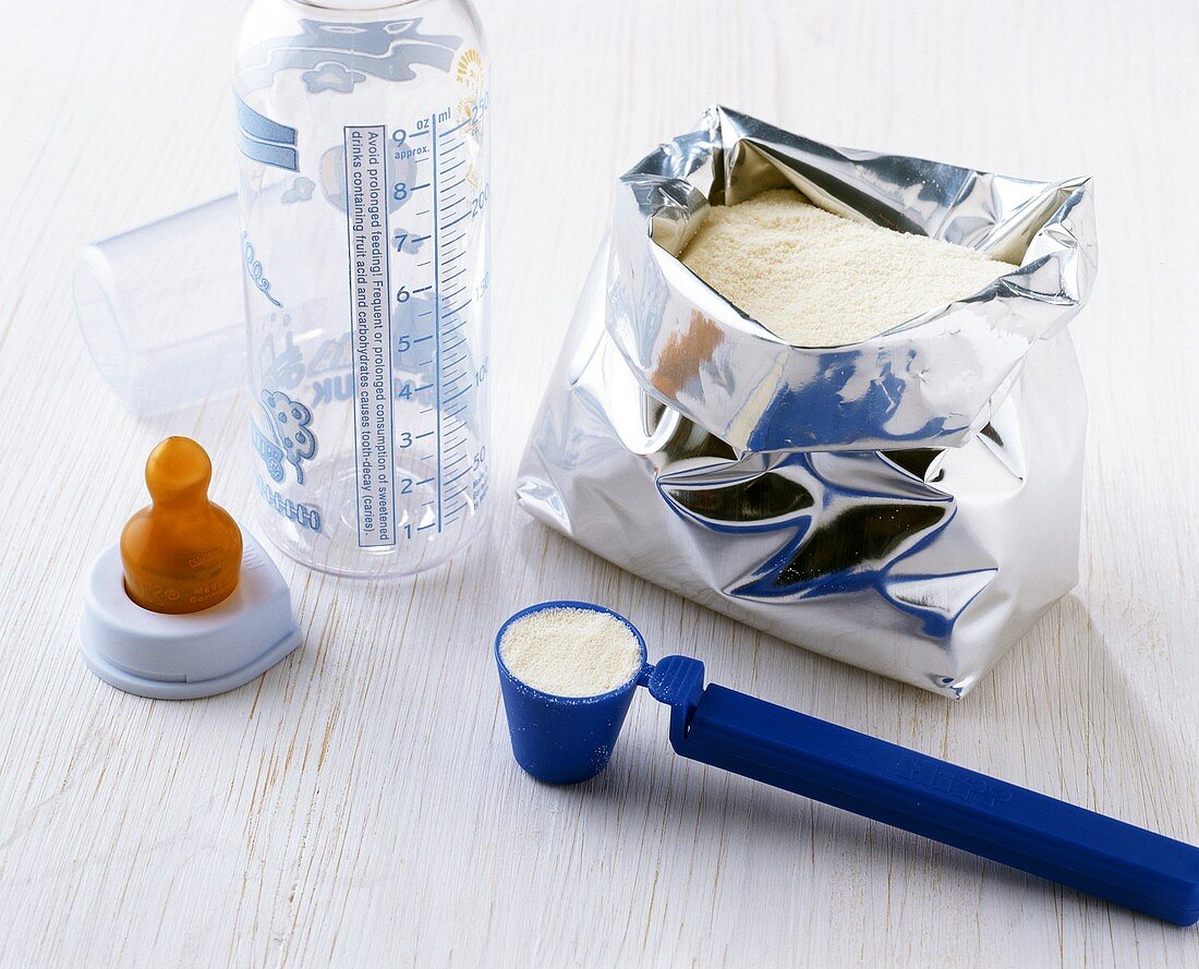 Preparing baby food: measuring powder with a measuring spoon