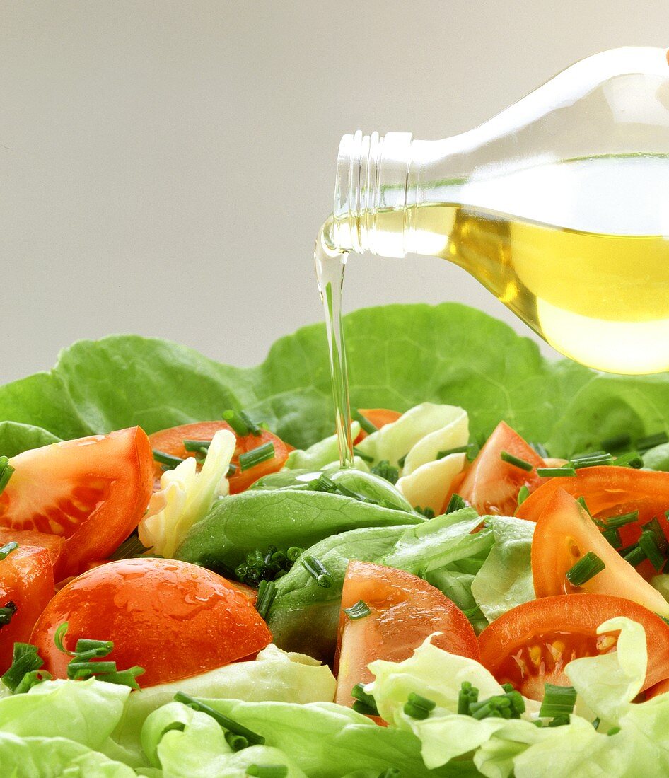 Drizzling mixed salad with oil