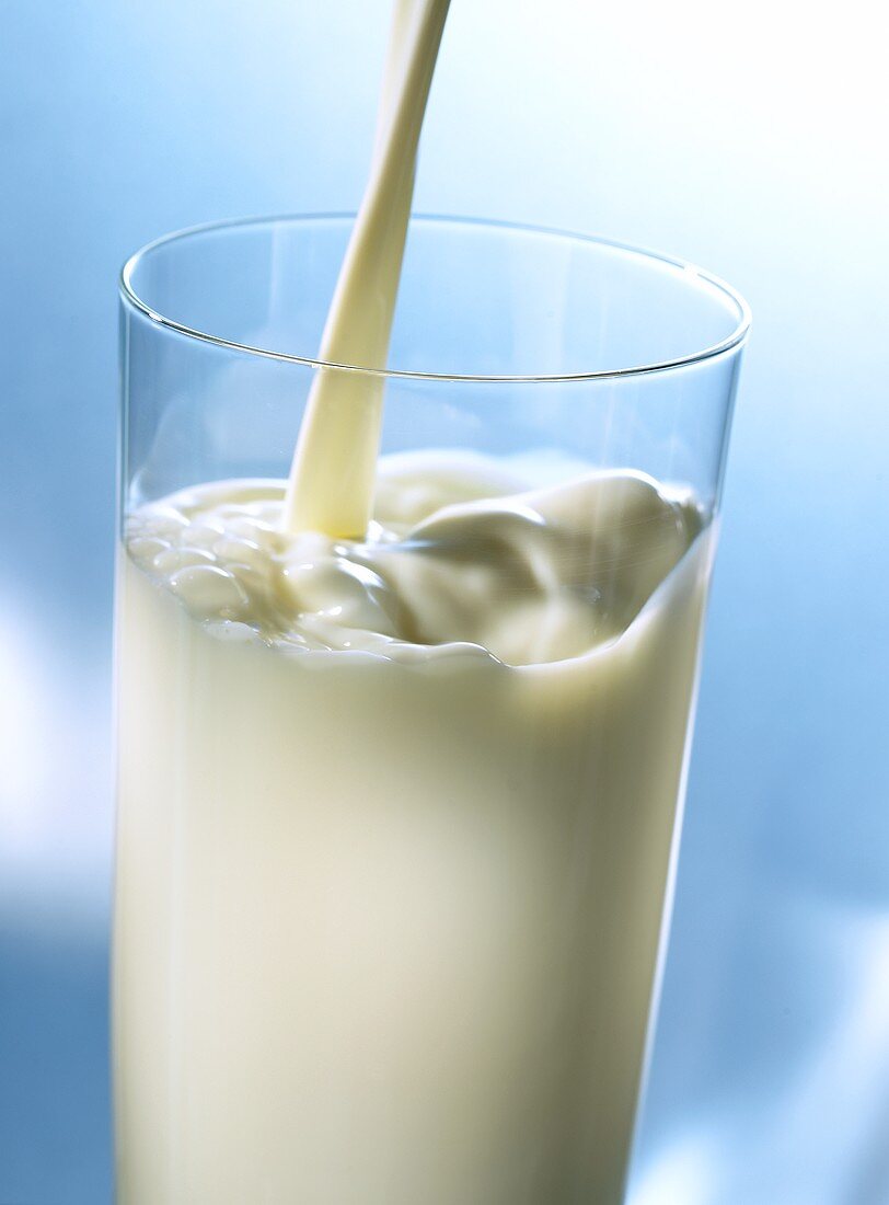 Milch wird ins Glas gegossen