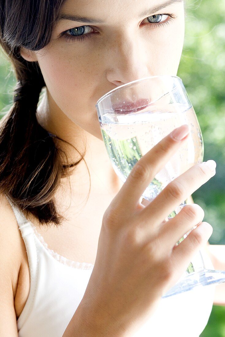 Junge Frau trinkt ein Glas Mineralwasser