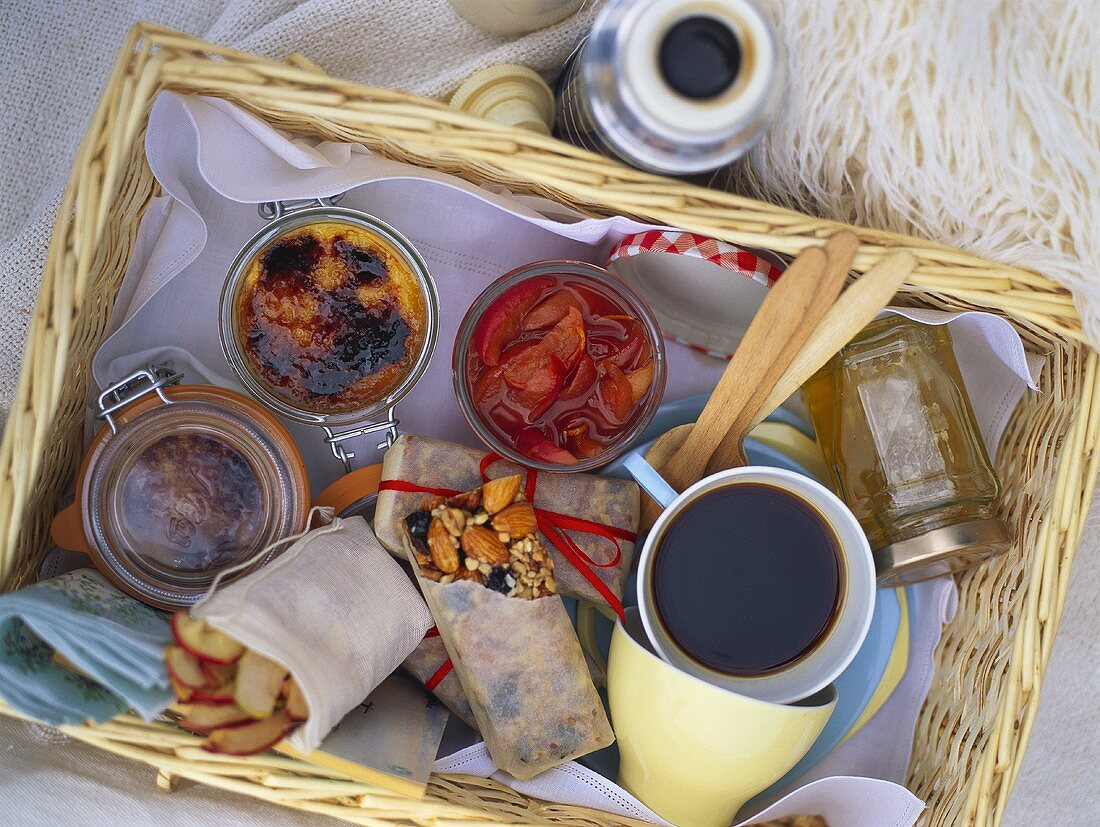 Picnic basket with coffee, desserts and snacks