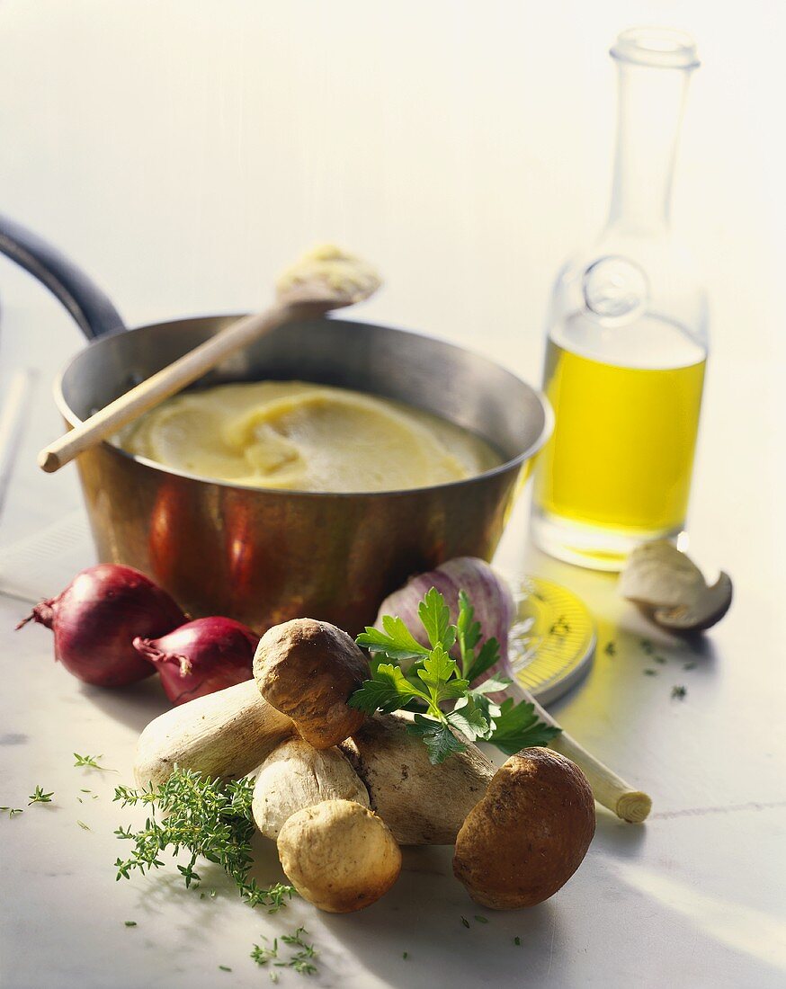 Stillleben mit Polenta, Steinpilz, Zwiebel, Knoblauch und Öl