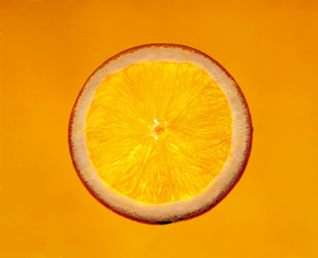 Eine Orangenscheibe vor orangefarbenem Hintergrund