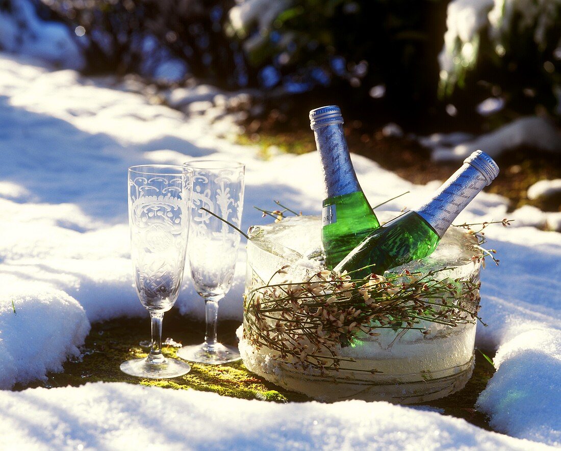 Two piccolo bottles & champagne glasses in wintry landscape