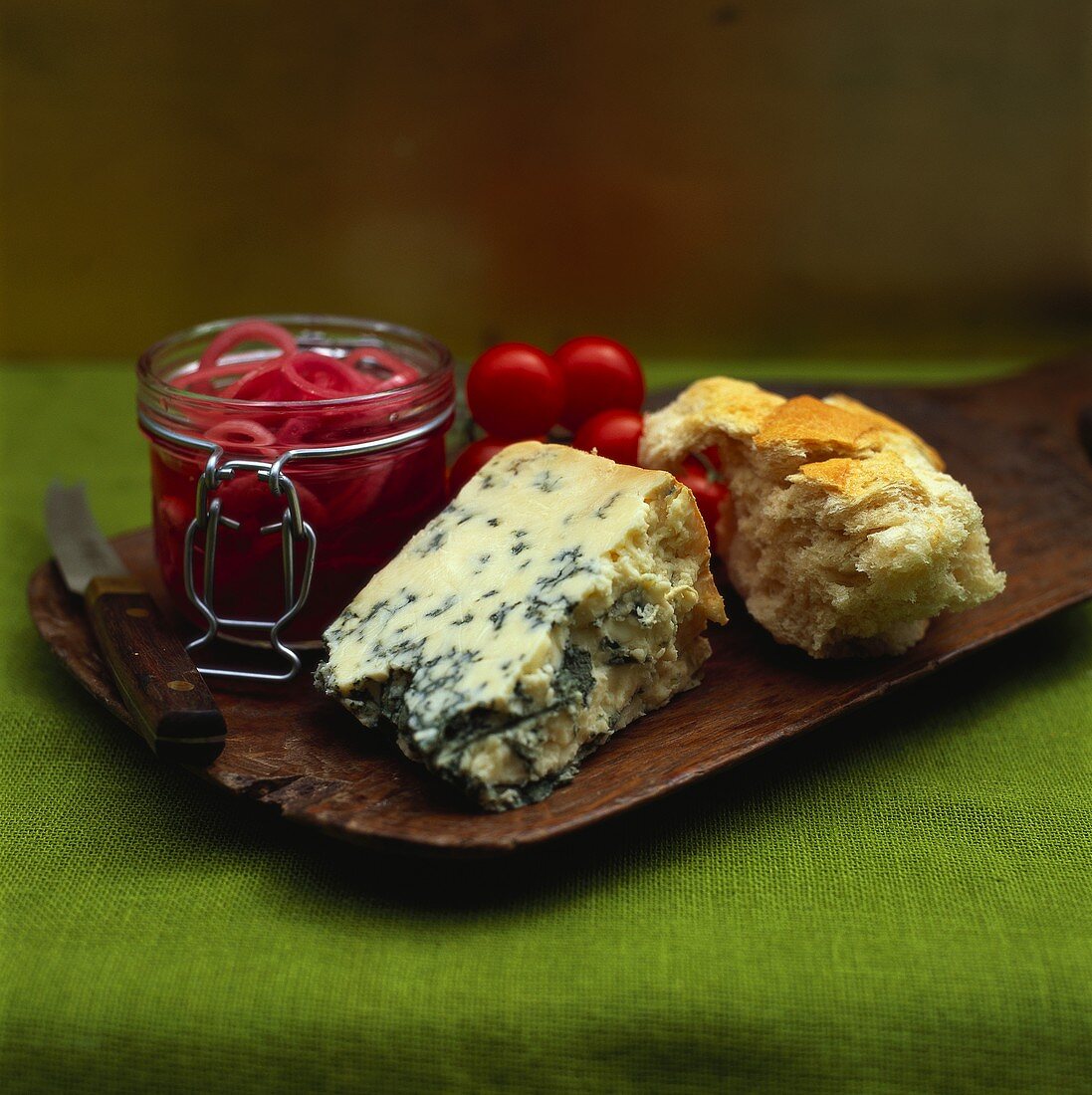 Board with blue cheese, bread and marinated onions