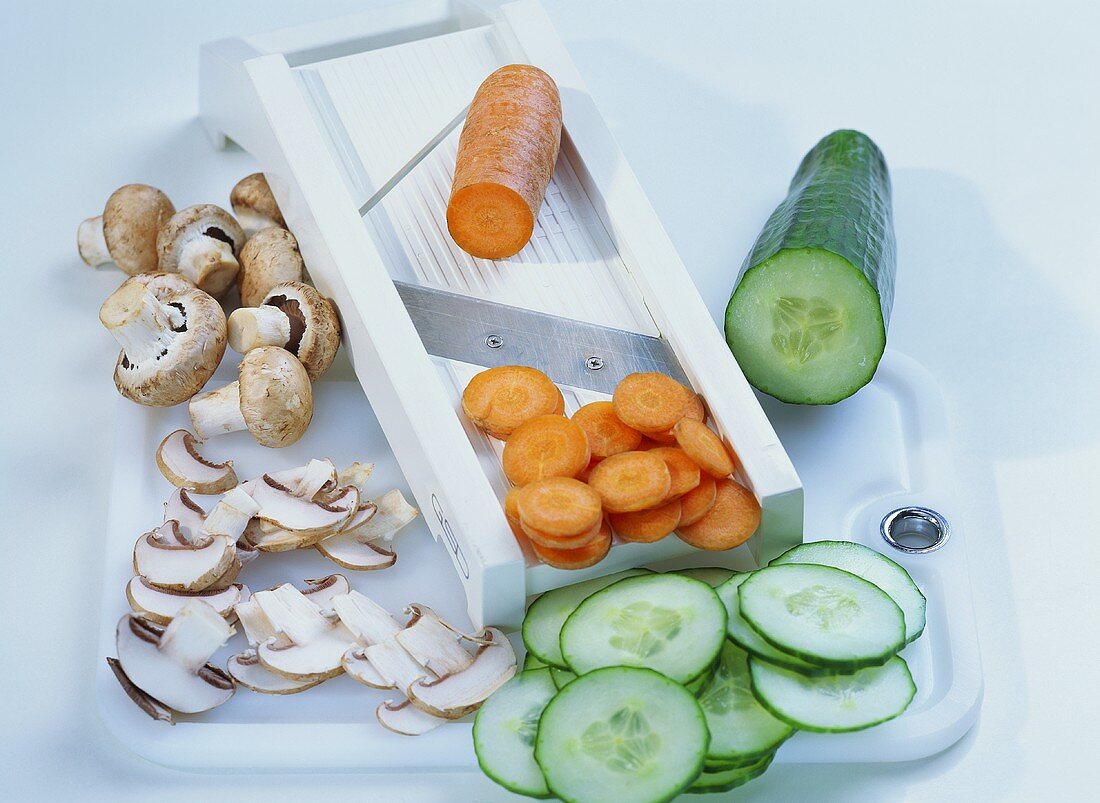 Vegetable slicer with slices of mushrooms, carrots and cucumber