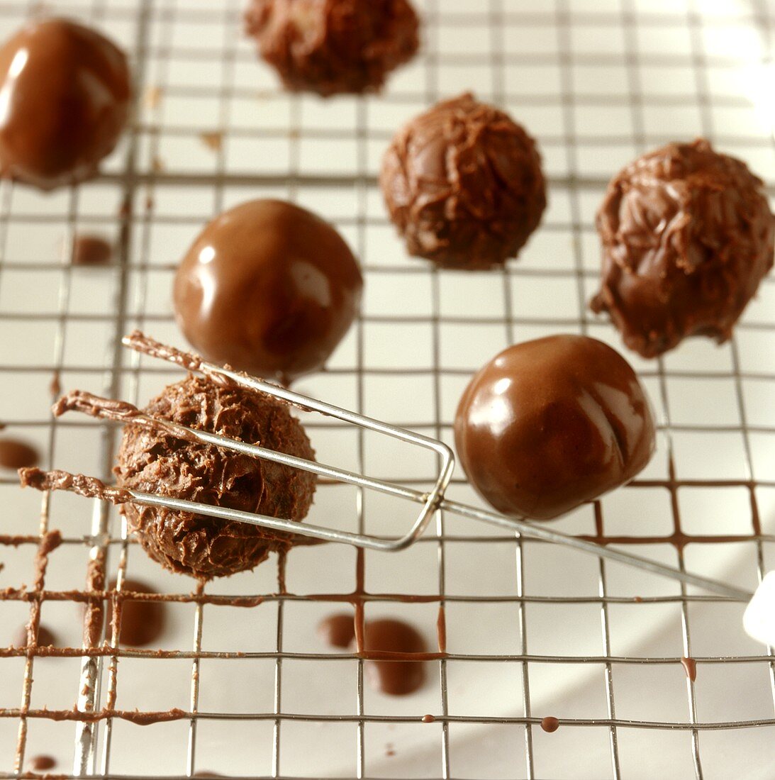 Rolling soft chocolate truffles over lattice with special fork