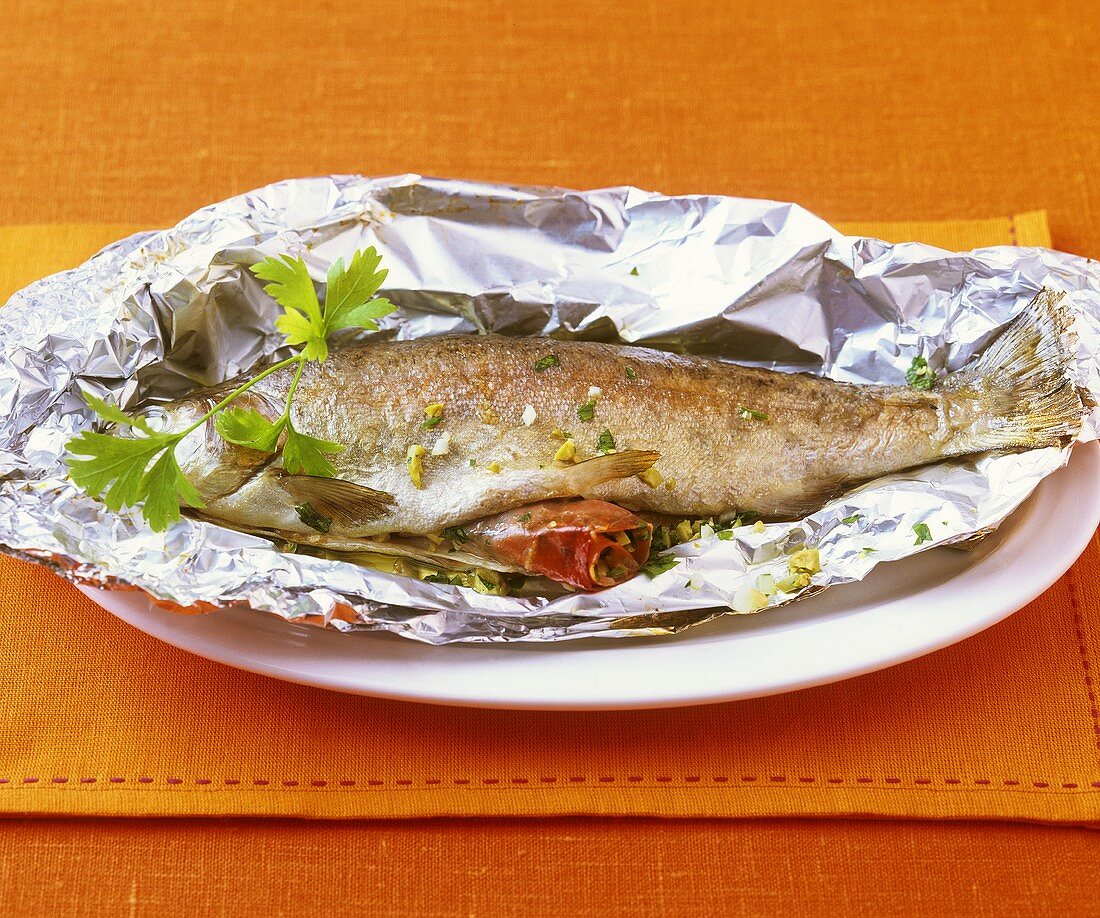 Trout stuffed with ham, cooked in foil
