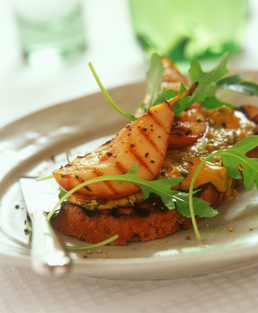 Mit Stilton überbackenes Brot mit gegrillter Birne und Rucola